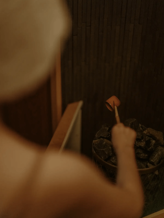 ロウリュをそそぐ女性