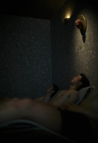 必要最低限の光によってコントラストが利いた空間で整う男性