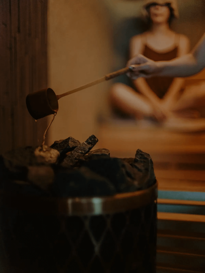 サウナストーンにロウリュ水をかける