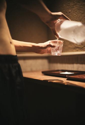 グラスに水を注ぐ女性