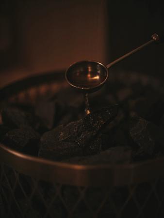 サウナストーンにロウリュ水をかける