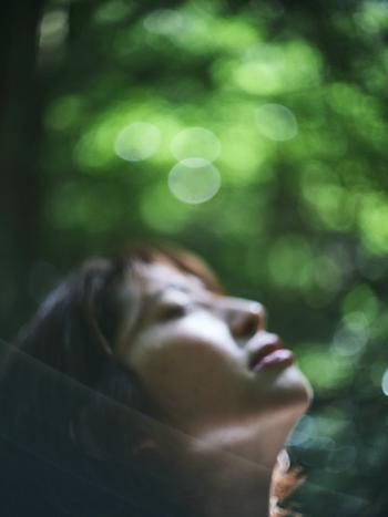 自然の中で空を見上げる女性