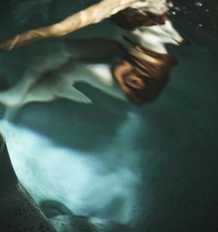 掛け流しで透き通る神秘の水風呂で深くもぐる女性