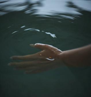 とろけて浸透する超軟水の水風呂を楽しむ女性の手