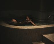 プライベートサウナルームの水深深い超軟水の水風呂につかる女性